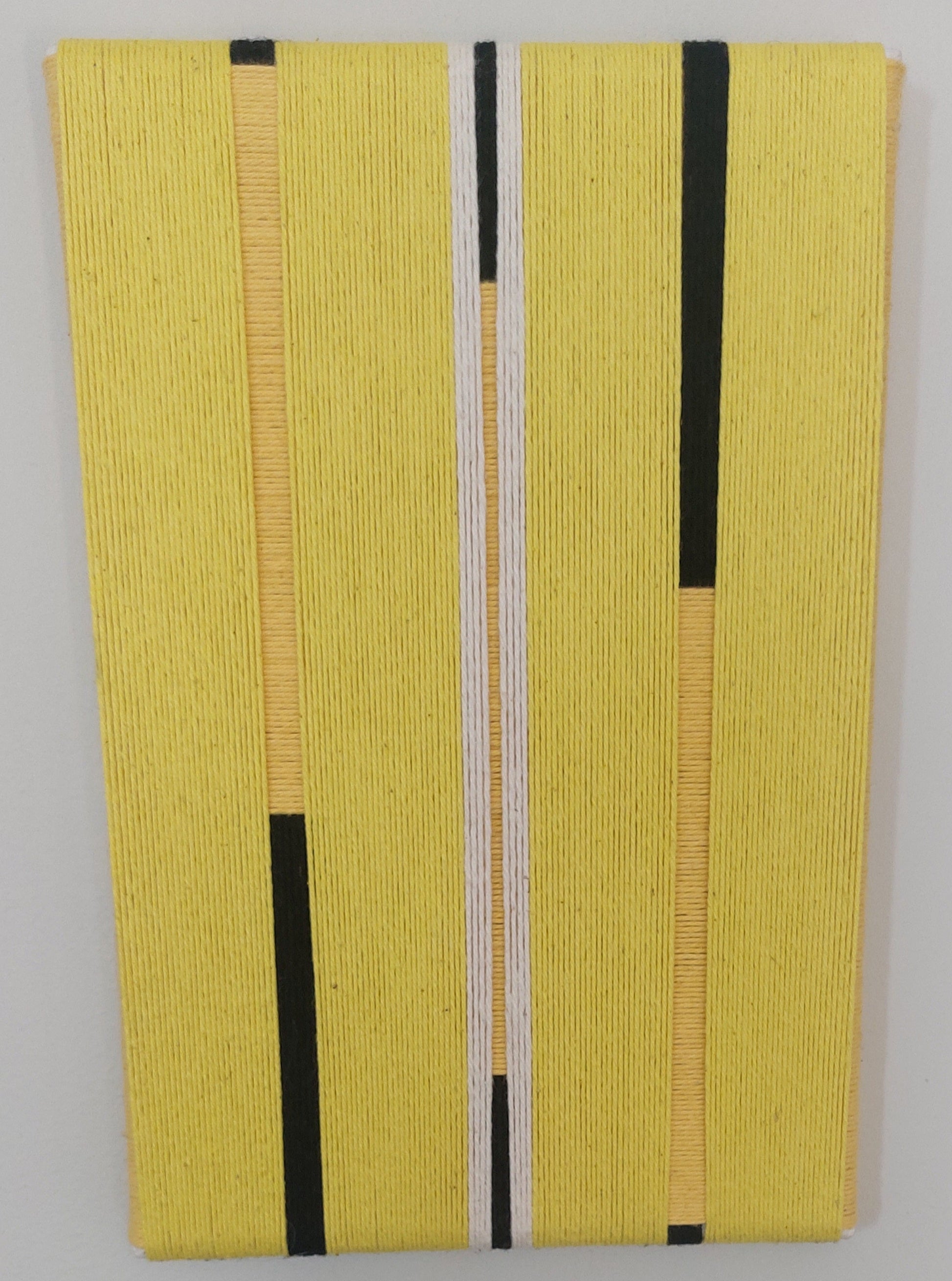 Yellow textile art with black and white stripes.