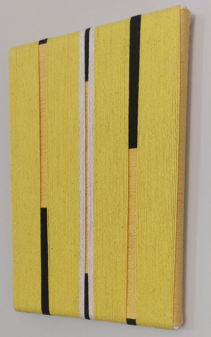 Yellow textile art with black and white stripes.