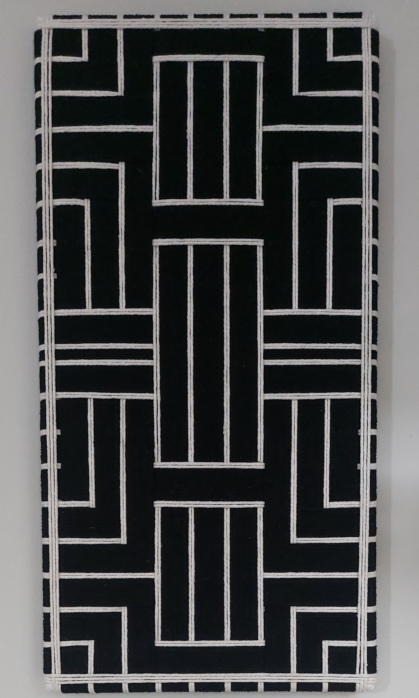 Black and cream modern textile wall art on a gray background