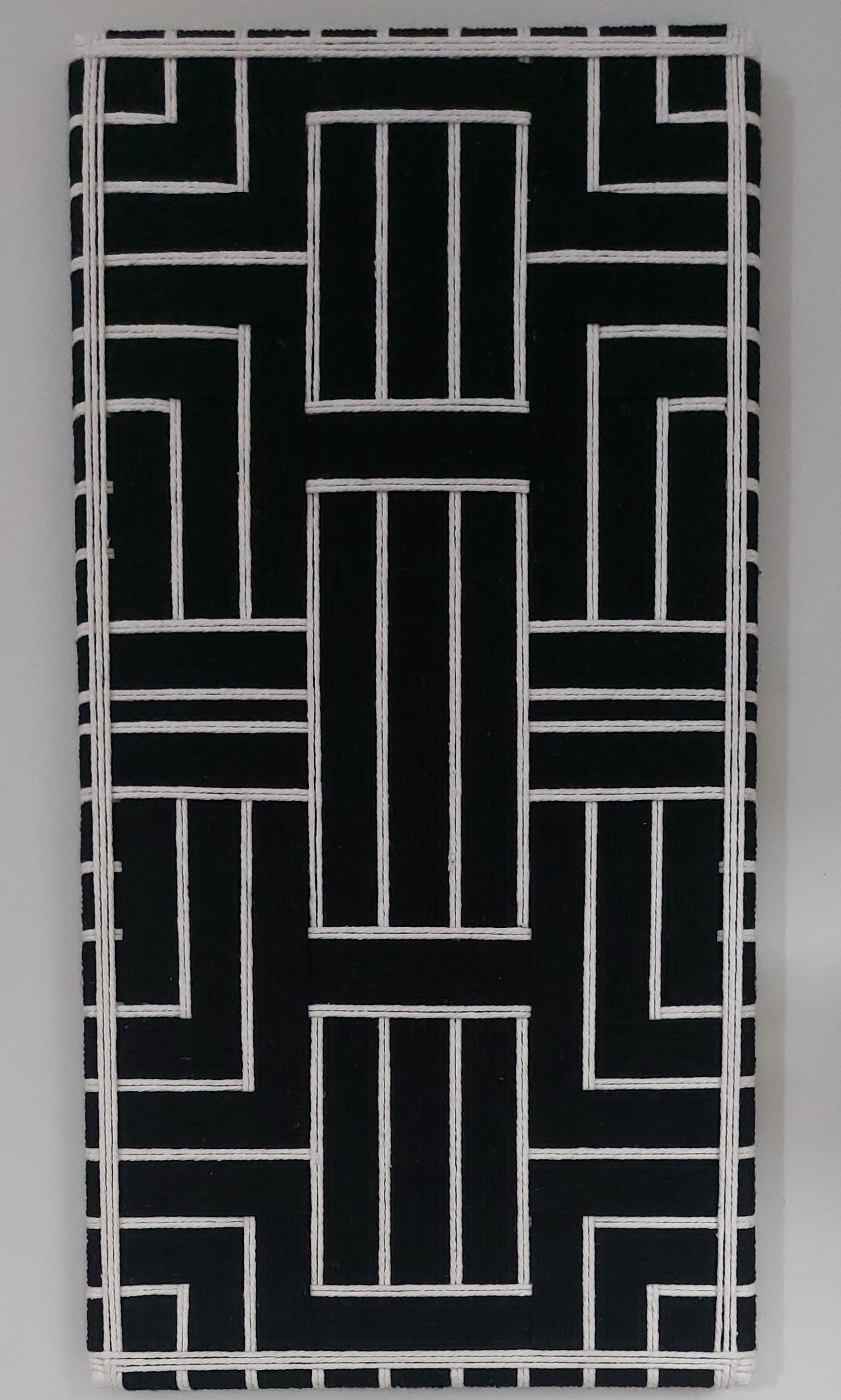 Black and cream modern textile wall art on a gray background